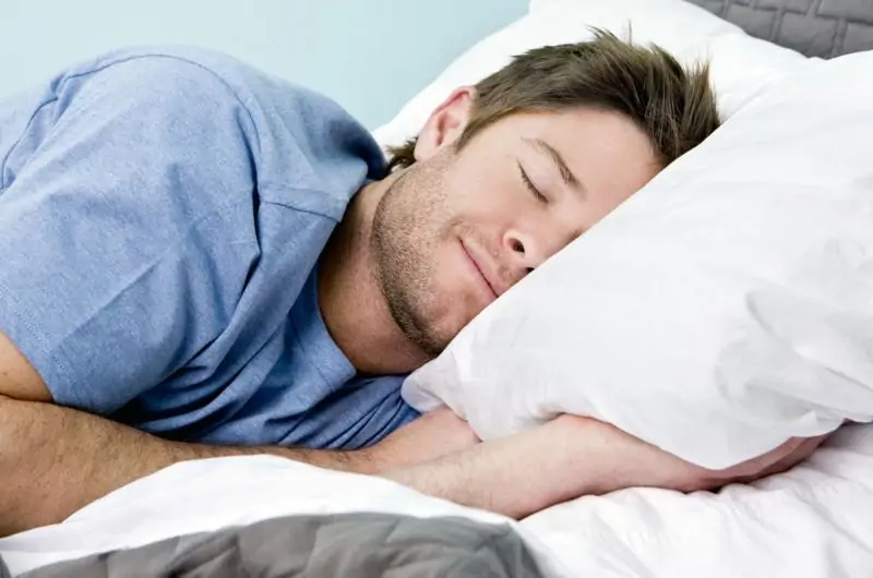 Persona descansando tranquilamente en una cama, representando la importancia de evitar no dormir bien para proteger la salud cerebral y física