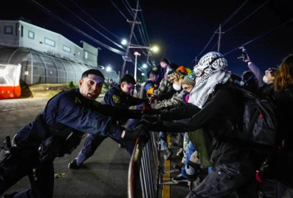 Manifestantes y fuerzas del orden se enfrentan con barricadas frente al centro Delaney Hall de GEO Group.