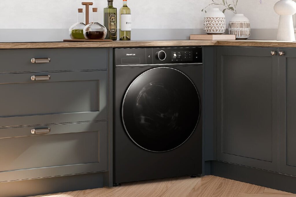 Vista frontal de una lavasecadora inteligente empotrada a ras de los muebles en una cocina moderna, representando la lavasecadora Hisense Serie 5i.