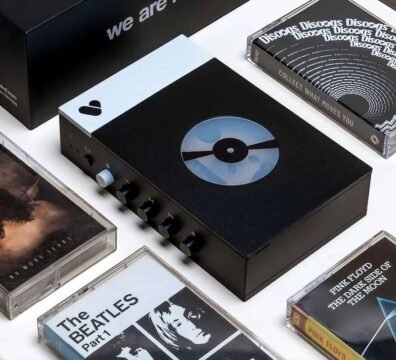 Un reproductor de cassette de aluminio moderno con conectividad Bluetooth junto a varias cintas magnéticas sobre una mesa, representando la tendencia del hardware retro.