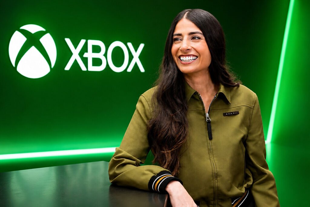Logotipo de Xbox iluminado en verde sobre un fondo oscuro de oficinas corporativas desalojadas, ilustrando las consecuencias de los recortes en XBOX.