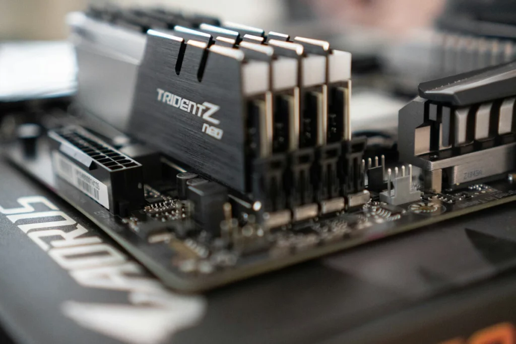 Primer plano de circuitos integrados y módulos de memoria RAM sobre una mesa de pruebas, ilustrando la manipulación de precios de los semiconductores.
