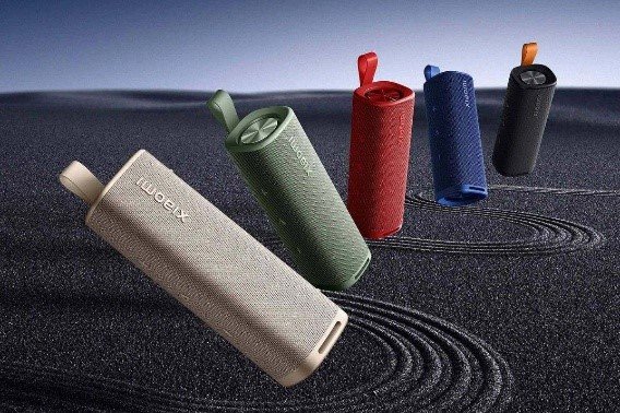 Una variedad de dispositivos tecnológicos inteligentes de Xiaomi incluyendo un reloj inteligente, auriculares inalámbricos y un parlante portátil ordenados sobre una mesa, representando el ecosistema AIoT de Xiaomi.