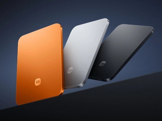 Una variedad de dispositivos tecnológicos inteligentes de Xiaomi incluyendo un reloj inteligente, auriculares inalámbricos y un parlante portátil ordenados sobre una mesa, representando el ecosistema AIoT de Xiaomi.