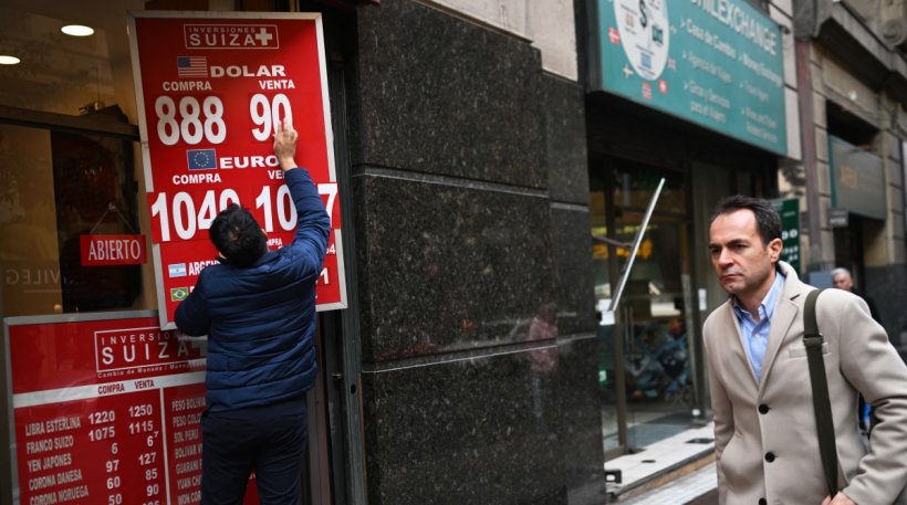 Un trabajador transita frente a un establecimiento comercial de casas de cambio en la ciudad de Santiago de Chile.