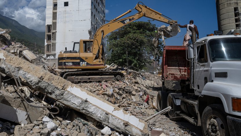 Damnificado buscando pertenencias entre los bloques de concreto colapsados en La Guaira tras el desastre natural.