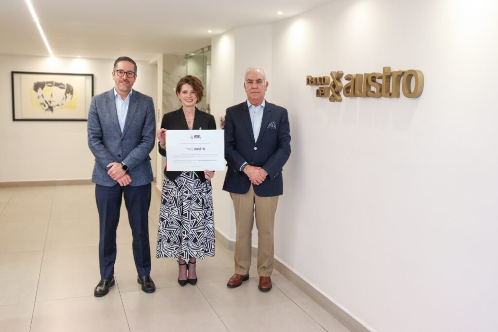 Guillermo Talbot, Clemente Tamariz y Mónica Malo sostienen el convenio de incorporación institucional en Cuenca, representando la alianza con el Banco del Austro.