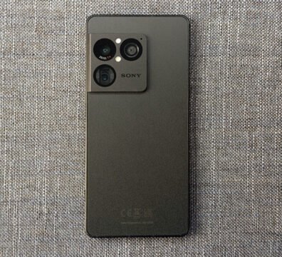 Vista frontal de la pantalla OLED encendida de el Sony Xperia 1 VIII junto a unos auriculares de cable conectados a su puerto superior de 3,5 mm.
