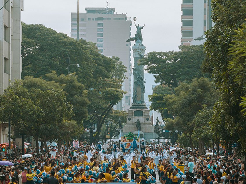 Carro alegórico y bailarines participando en el desfile por las fiestas de fundación de Guayaquil.