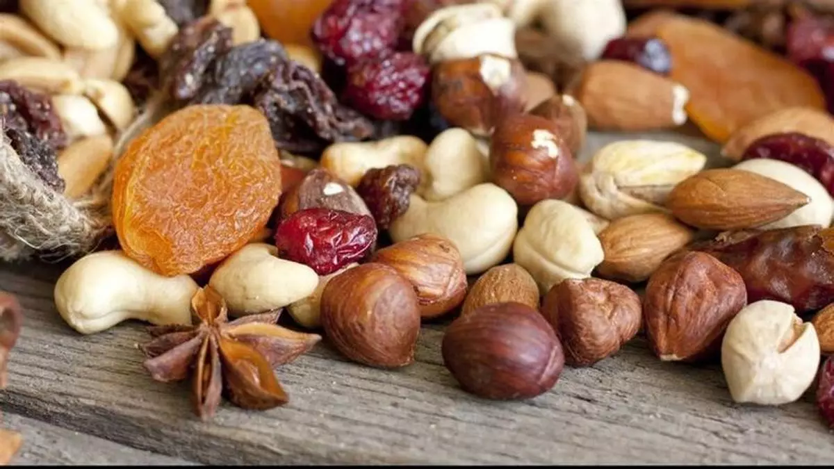 : Porción variada de frutos secos como nueces, almendras y avellanas, relacionados con beneficios en la fertilidad masculina