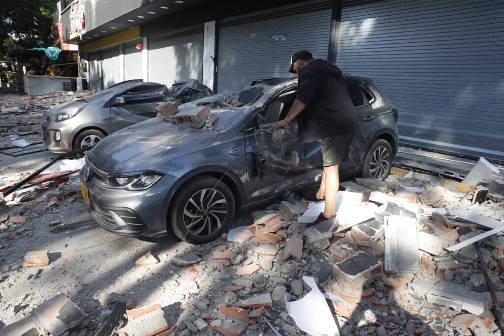 Hombre observando un vehículo afectado por las consecuencias del terremoto de 7,4 en Colombia.