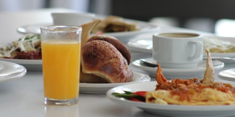Un plato con alimentos de desayuno sobre una mesa, ilustración sobre el hábito de desayunar todos los días y sus efectos en la salud y el peso corporal según estudio científico