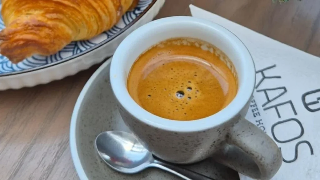 Taza de café de especialidad servida con arte latte en una cafetería moderna