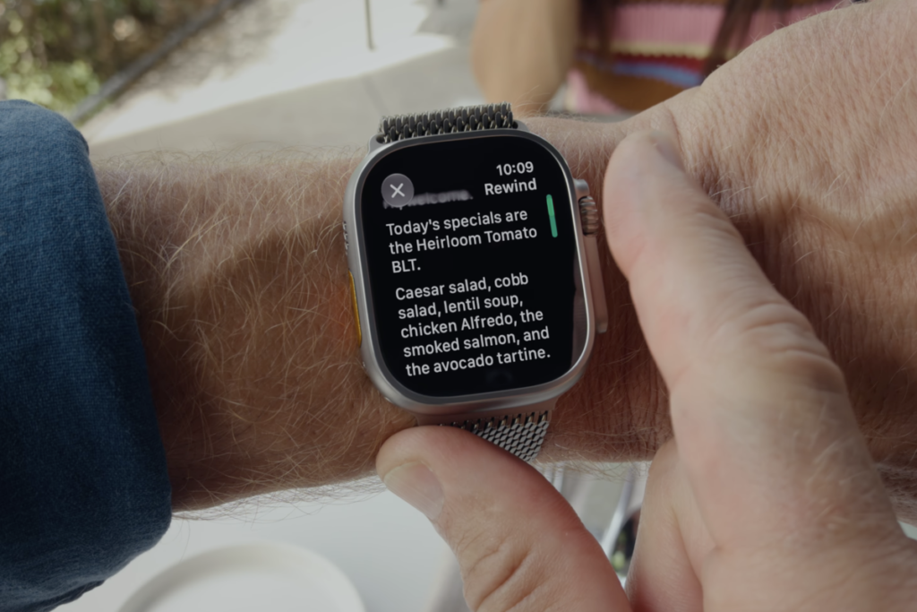 Usuario revisando un texto generado por las funciones del Apple Watch en la muñeca.
