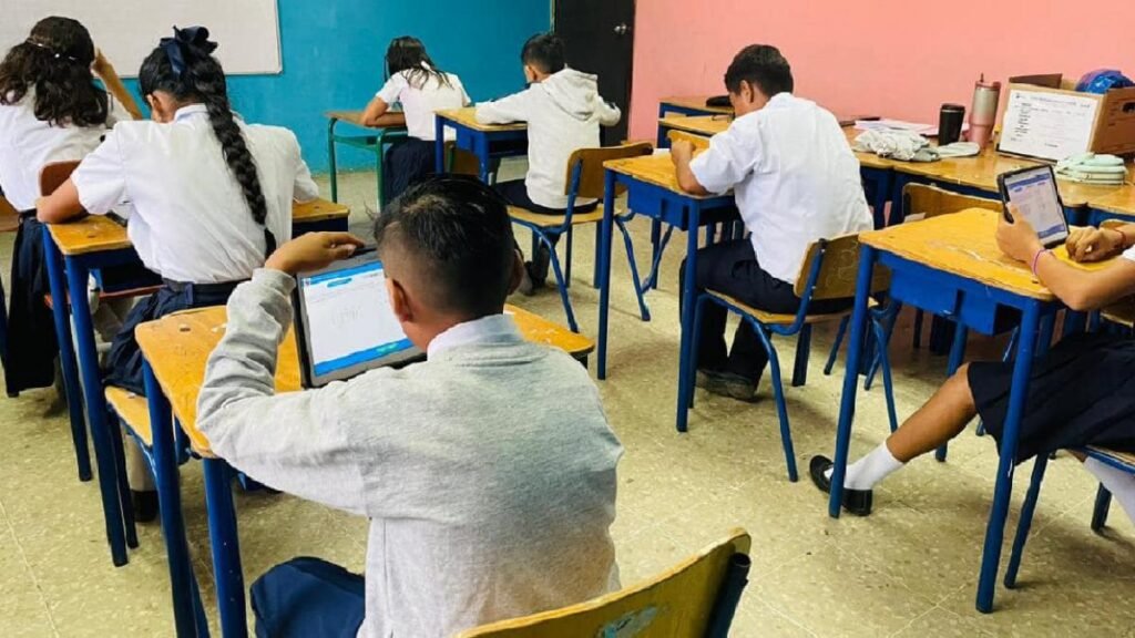 Estudiantes secundarios reunidos en una aula escolar rindiendo las pruebas PISA Ecuador en una unidad educativa pública.