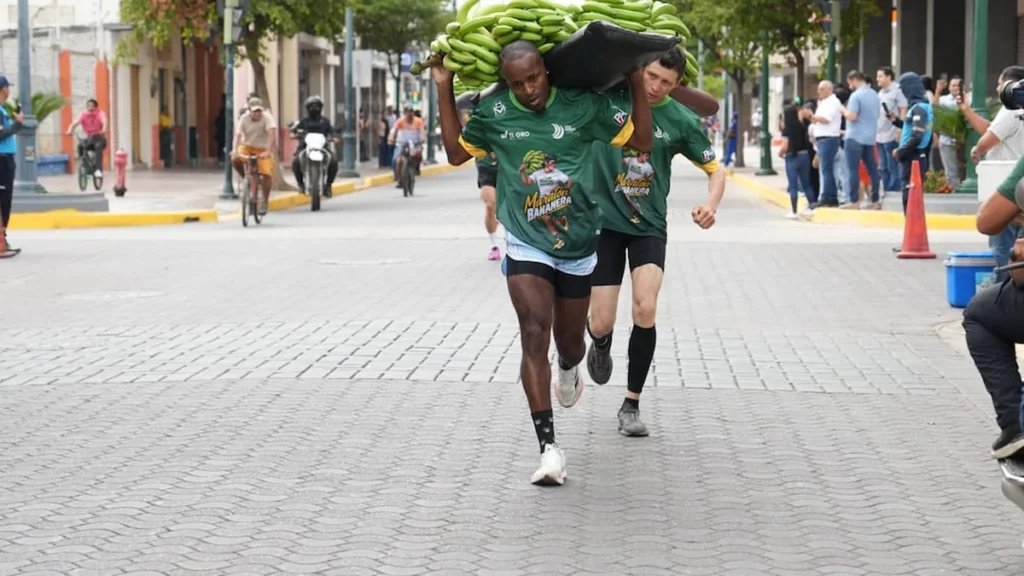 Abraham Tolosa corriendo con racimo de banano al hombro en Machala