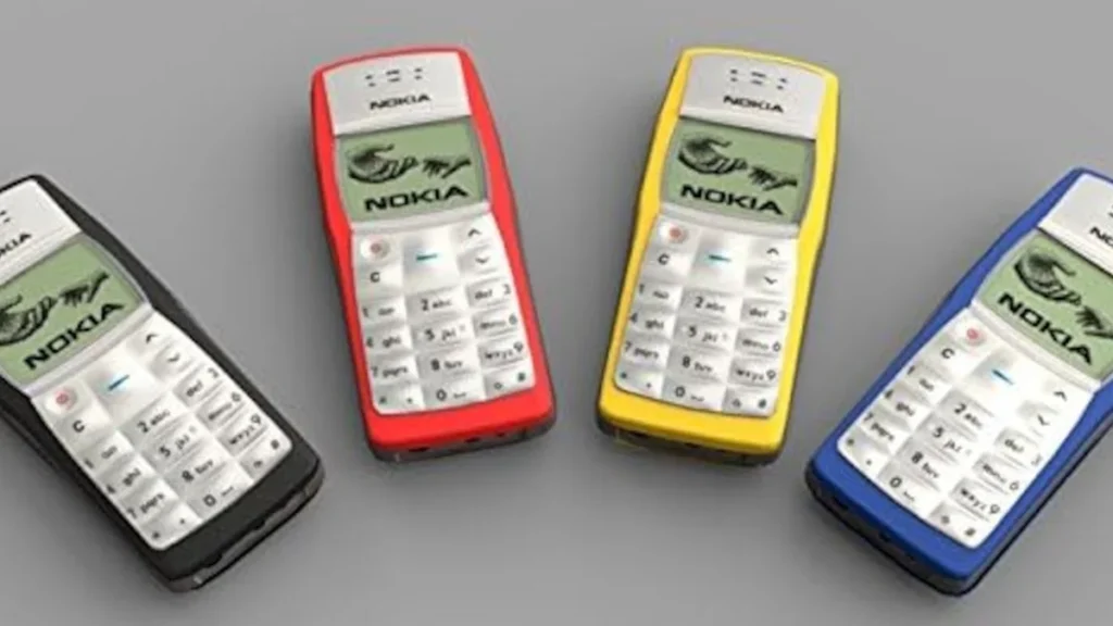 Teléfono clásico Nokia 1100 en color gris sobre una mesa de trabajo