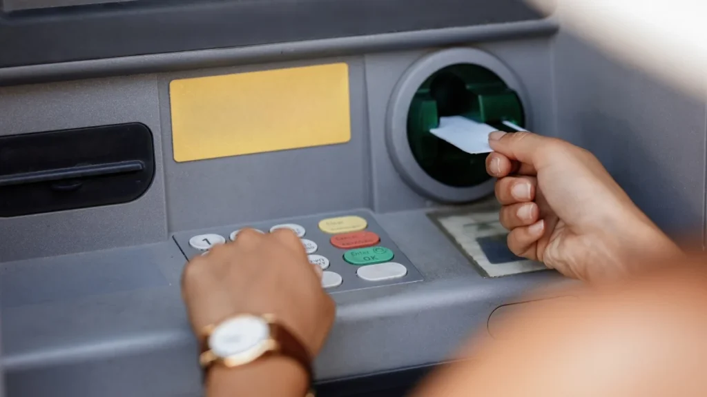 Usuario realizando retiro de dinero en cajero automático bancario de Ecuador
