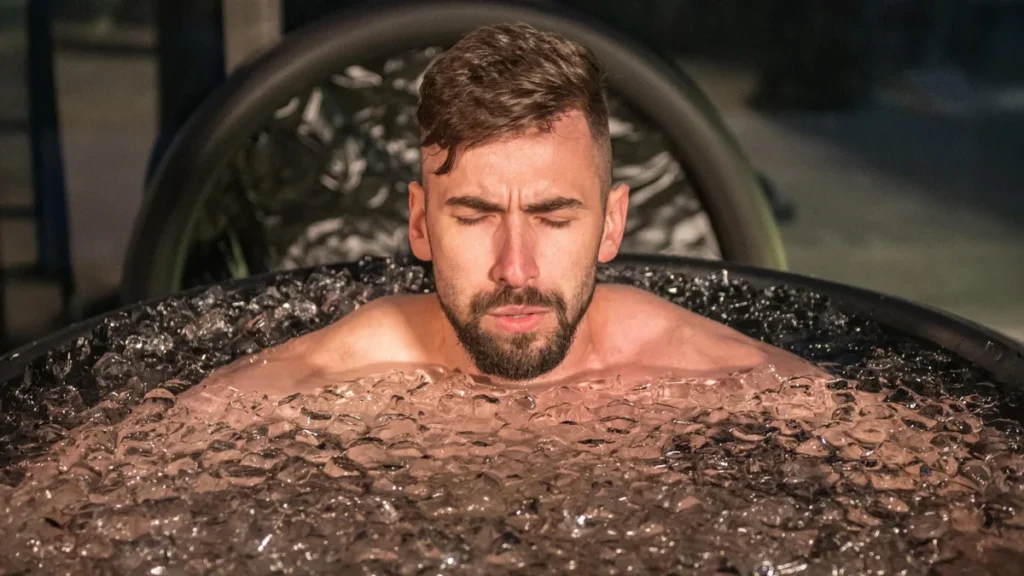 Atleta descansando tras una intensa sesión de entrenamiento de fuerza en el gimnasio