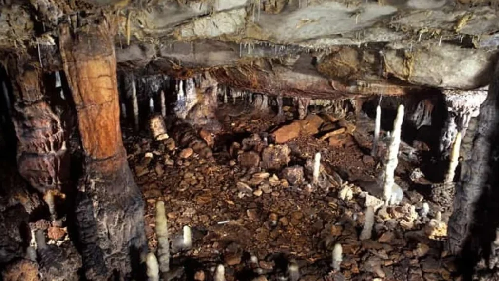 Entrada rocosa a una cueva prehistórica con formaciones geológicas de calcita