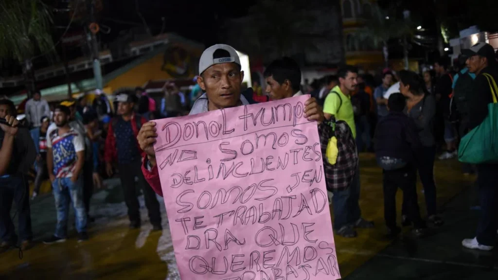 Manifestación laboral y bandera de Estados Unidos frente a edificio gubernamental