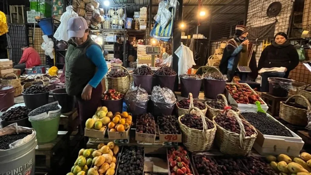 Comerciantes exhibiendo moras, mortiños y hierbas aromáticas en el Mercado Mayorista de Quito