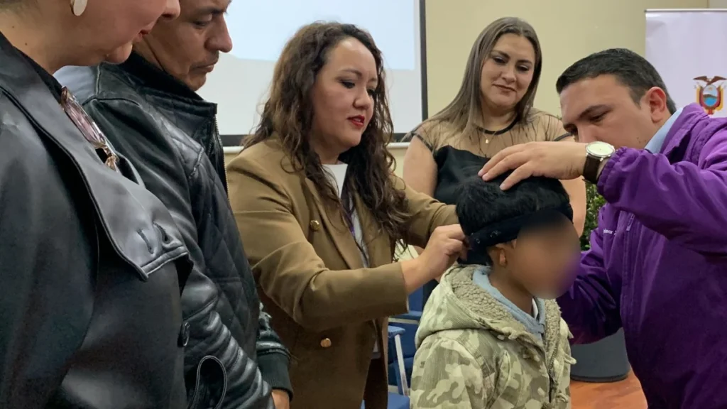 Especialista colocando un dispositivo de audífono a un paciente en hospital público