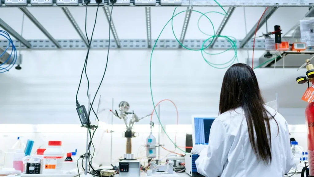 Científica e investigadora analizando documentos académicos en biblioteca universitaria