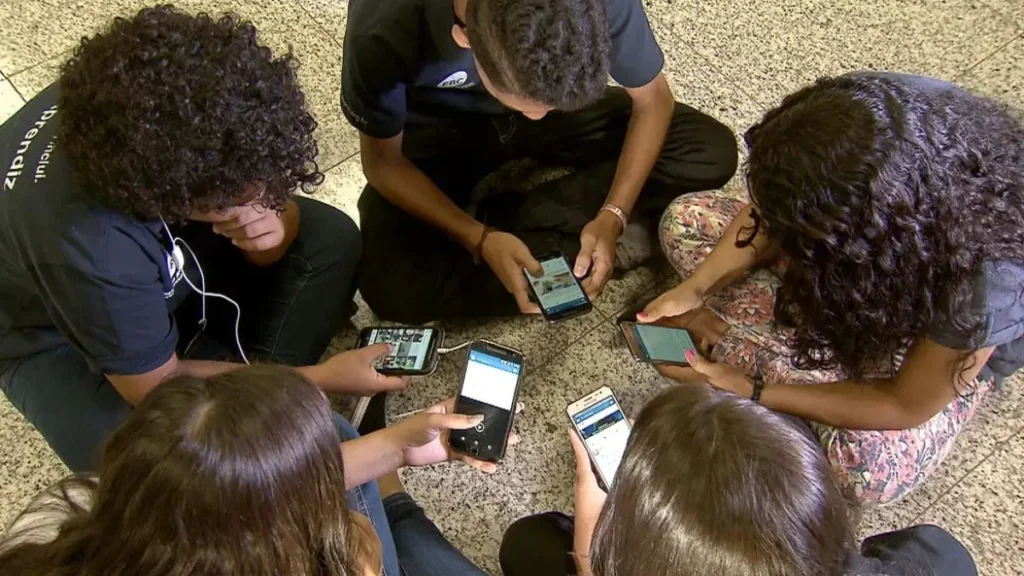 Estudiantes utilizando dispositivos digitales en un salón de clases