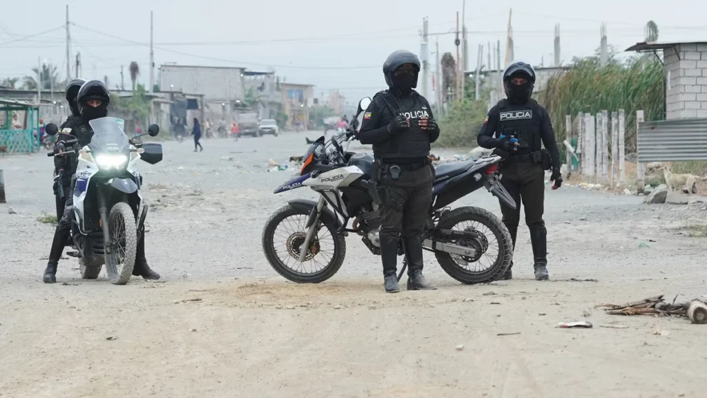 Patrullero de la Policía Nacional y agentes acordonando una zona intervenida en Machala